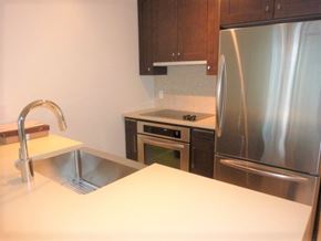 Vancouver apartment for rent - A kitchen with a stainless steel refrigerator and a sink with a faucet.