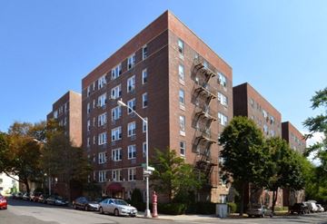 Bronx apartment for rent - a tall brick apartment building with a fire escape