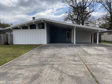 Nederland house for rent - a white garage with a driveway and a white house