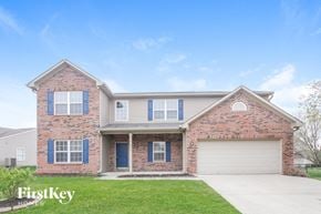 Indianapolis house for rent - A brick house with a garage door and a blue door.