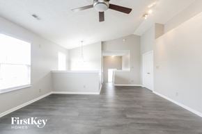 Indianapolis house for rent - A spacious room with a ceiling fan and a large window.
