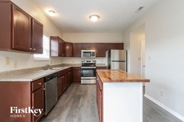 Indianapolis house for rent - A kitchen with brown cabinets and a wooden island.