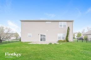 Indianapolis house for rent - A two-story house with a grey exterior and a white window.