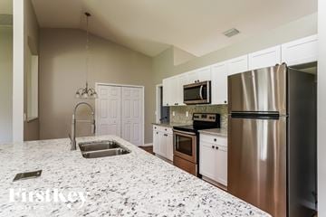 Lehigh Acres house for rent - a kitchen with stainless steel appliances and granite counter tops