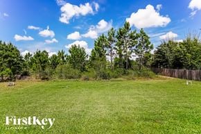 Lehigh Acres house for rent - a large grassy field with trees and a fence
