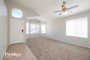 Mesa house for rent - an empty living room with a ceiling fan and a white door