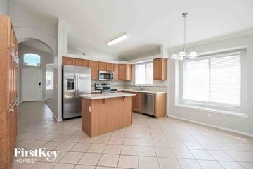 Mesa house for rent - a large kitchen with wooden cabinets and stainless steel appliances