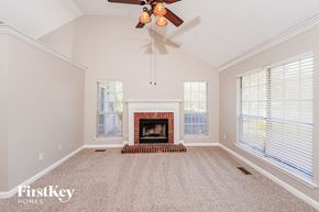 Pinson house for rent - A spacious living room with a fireplace and a ceiling fan.