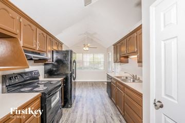 Pinson house for rent - A kitchen with wooden cabinets and black appliances.