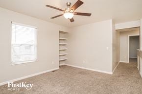 Colorado Springs house for rent - a bedroom with a ceiling fan and a book shelf