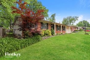Saint Louis house for rent - a brick house with a green lawn and trees