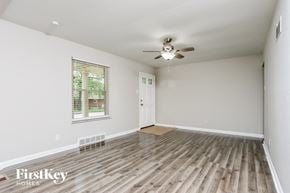 Saint Louis house for rent - an empty living room with wood floors and a ceiling fan