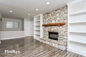 Saint Louis house for rent - a living room with a stone fireplace and white shelves