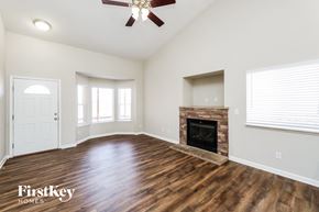 Coloradosprings house for rent - A spacious living room with a fireplace and a ceiling fan.
