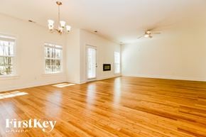 Summerville house for rent - A room with wooden floors and a chandelier.