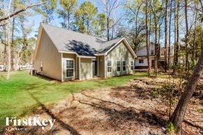 Summerville house for rent - A house with a green lawn and trees in the background.