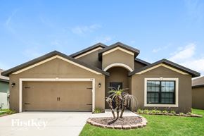 Lehigh Acres house for rent - A house with a brown garage door and a palm tree in front.