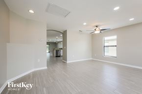 Lehigh Acres house for rent - A spacious room with a FirstKey Homes logo on the bottom left corner.