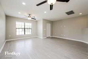 Lehigh Acres house for rent - A spacious room with a ceiling fan and lighting fixtures.
