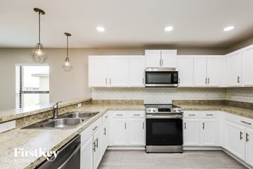 Lehigh Acres house for rent - A modern kitchen with white cabinets and a stainless steel oven.