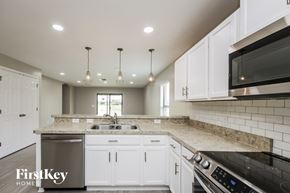 Lehigh Acres house for rent - A kitchen with white cabinets and a black stove top oven.