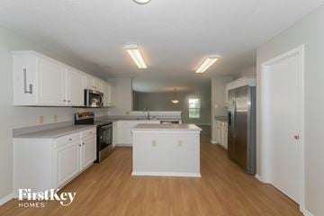 Fishers house for rent - A kitchen with white cabinets and a wooden floor.