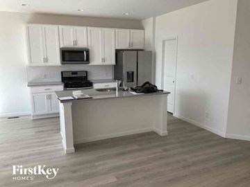 Mead house for rent - an empty kitchen with white cabinets and a counter top