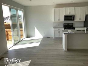 Mead house for rent - an empty kitchen with white cabinets and a window