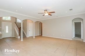 Humble house for rent - an empty living room with a ceiling fan and a staircase