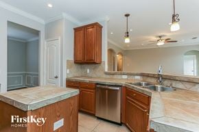 Humble house for rent - a kitchen with wooden cabinets and stainless steel appliances