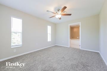 Lehigh Acres house for rent - a spacious living room with carpet and a ceiling fan