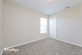 Lehigh Acres house for rent - a bedroom with a carpeted floor and a white door