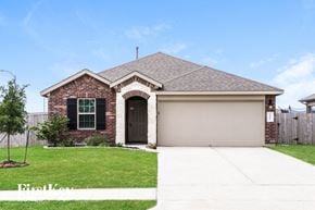 Baytown house for rent - a home with a garage door and a lawn
