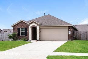 Baytown house for rent - a brick house with a garage door and a lawn