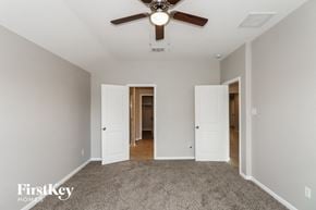 Baytown house for rent - a bedroom with carpet and a ceiling fan