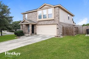 San Antonio house for rent - a brick house with a white garage door and a driveway