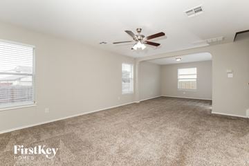 San Antonio house for rent - a living room with carpet and a ceiling fan