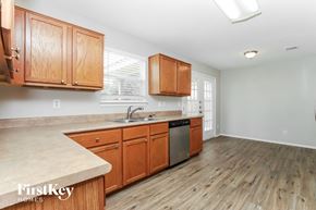 San Antonio house for rent - a kitchen with wooden cabinets and a sink and a dishwasher