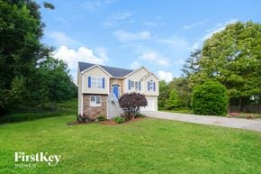 Rydal house for rent - A house with a blue door and windows is surrounded by greenery.