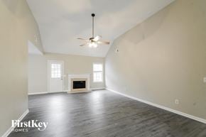 Rydal house for rent - A spacious room with a fireplace and a ceiling fan.