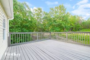 Rydal house for rent - A wooden deck with a railing and trees in the background.