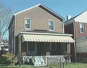 Glassport house for rent - A house with a brown siding and a white awning.