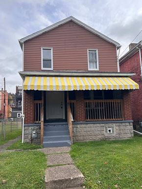 Glassport house for rent - A red house with a yellow and white striped awning.
