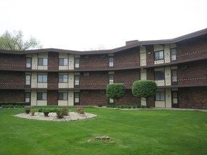 Lansing apartment for rent - an apartment building with a large yard in front of it