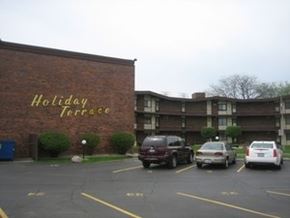 Lansing apartment for rent - a parking lot with cars in front of a holiday terrace building