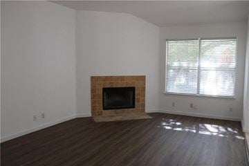 Cedar Park house for rent - a living room with a fireplace and wooden floors