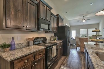 Lenexa apartment for rent - an updated kitchen with black appliances and granite counter tops