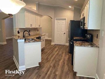 Middleburg house for rent - a kitchen with white cabinets and a black refrigerator
