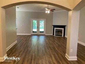 Middleburg house for rent - a empty living room with a fireplace and a ceiling fan