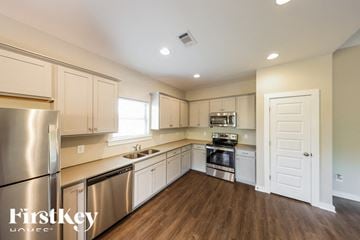 Parrish house for rent - A kitchen with wooden floors and stainless steel appliances.